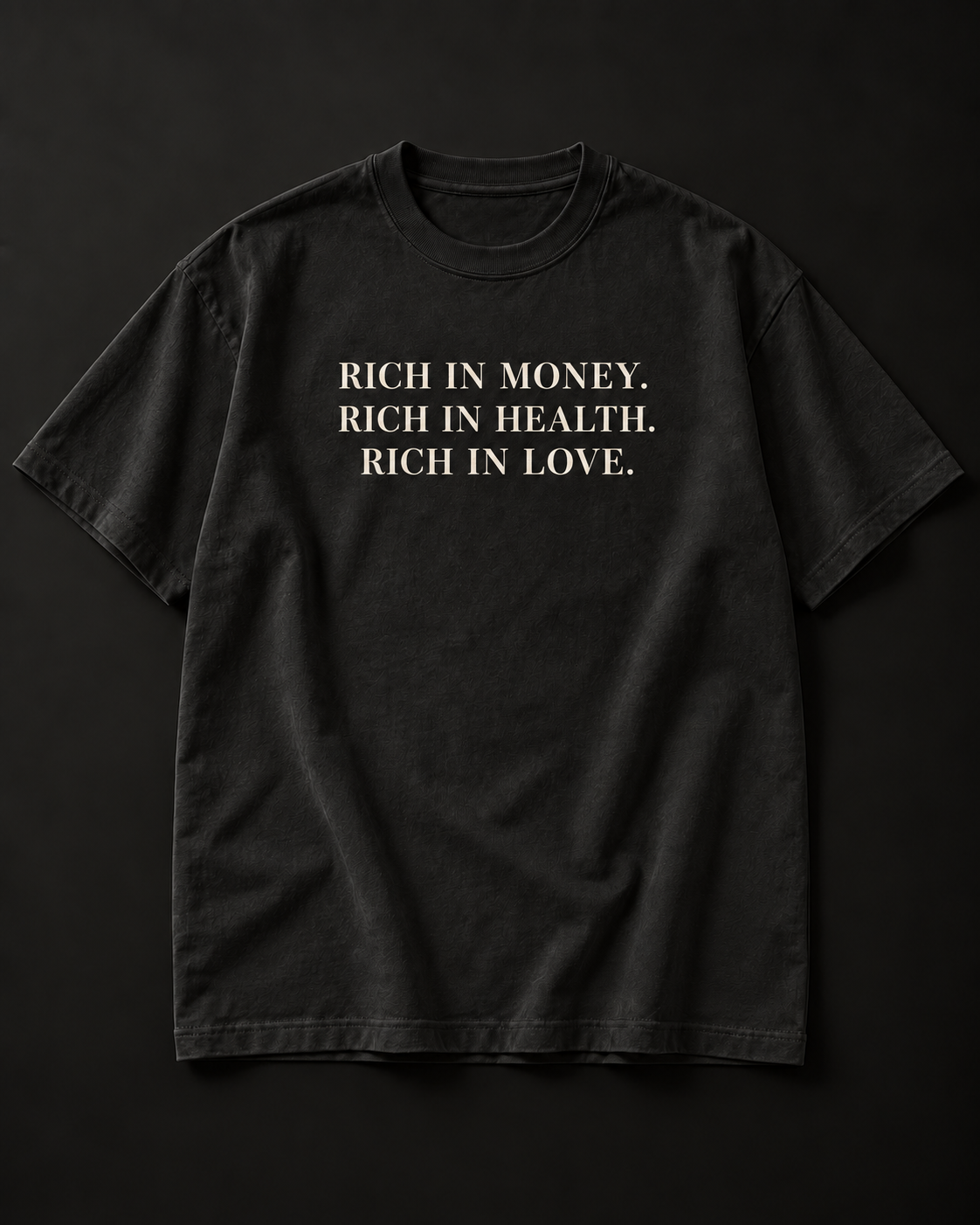 RICH IN MONEY. RICH IN HEALTH. RICH IN LOVE. heavyweight tee in washed black with a three-line stacked serif front print.